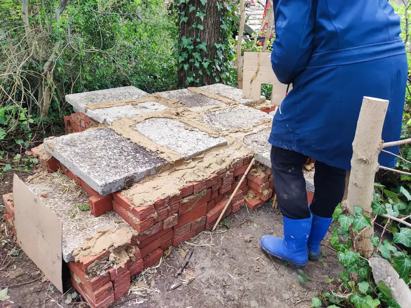 Het dak zit erop en de kieren worden met leem dichtgemaakt.